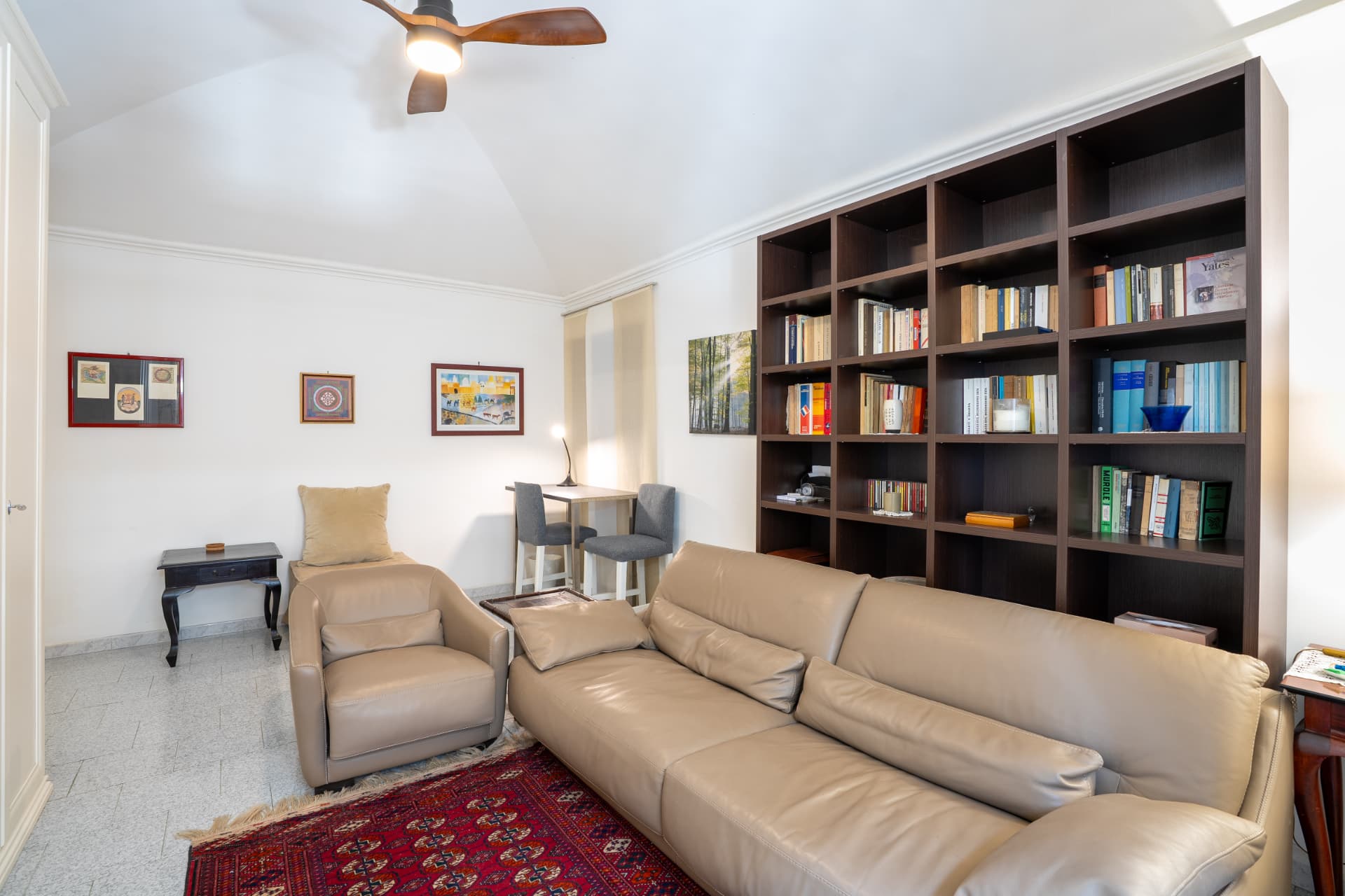 Salotto con divano in pelle, libreria e angolo scrivania